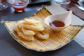 Ika Furai - Deep fried squid rings coated in panko breadcrumbs served with soy sauce and background chili sauce