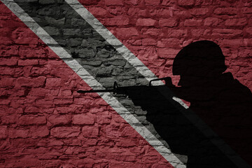 Soldier silhouette on the old brick wall with flag of trinidad and tobago country.