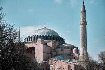 Fototapeta na wymiar Hagia sophia mosque, political figure of the old museum and orthodox church and mosque facade and it minaret through blue and clear, noise sky background photo.