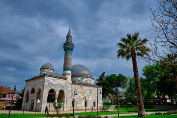 Fototapeta na wymiar Outside and facade view of Green Mosque in iznik and palm tree. Old ottoman and byzantine city of Iznik Bursa. Turkey 27.04.2021.