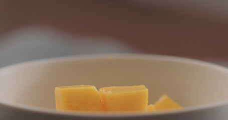 Mango cubes in white bowl