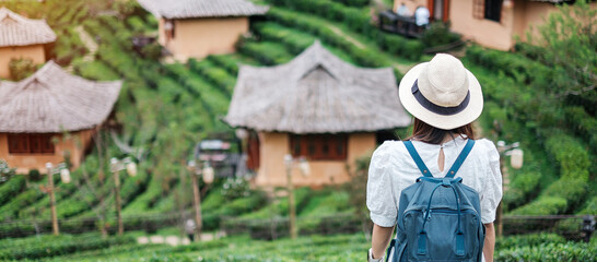 Happy tourist woman in white dress enjoy beautiful Tea garden.Traveler visiting in Ban Rak Thai...