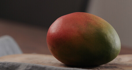 ripe red mango on olive wood board