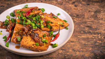 Stir fry tofu with onions and hot peppers in a plate, copy space for a recipe