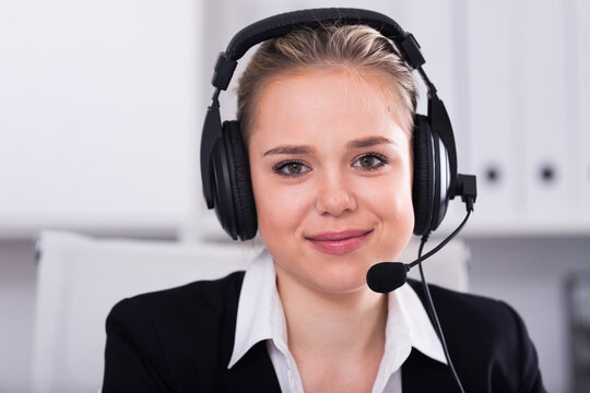 Portrait of smiling female customer support phone operator at workplace