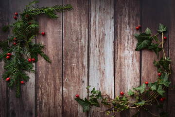 Branch of ivy and acorn on a brown, rustic wooden background, christmas wreath, vintage style