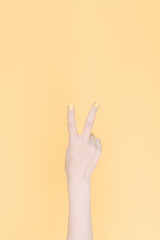hand showing number two In front of the yellow background,