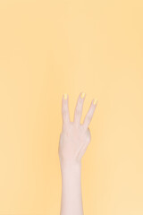 hand showing number three In front of the yellow background,
