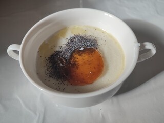semolina porridge with poppy seeds and jam in a white plate
