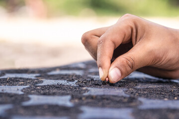 close up dirty  hand  sowing coriander seeds on soil