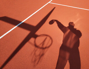 shadow of a basketball player throwing the ball into the basket