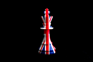 great britain flag paint over on chess king, black background. Copy space.