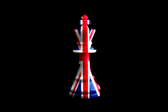 great britain flag paint over on chess king, black background. Copy space.