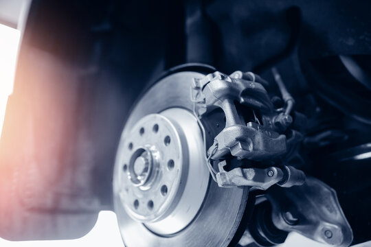 Concept for replacing wheel pads in garage. Closeup of steel brake disc in car service