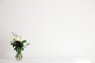 明るい白い壁に白い薔薇