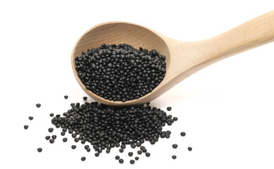 Black beluga lentils pile with wooden spoon isolated on white  