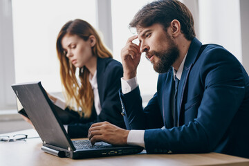 colleagues sitting at a desk with a laptop communication finance officials