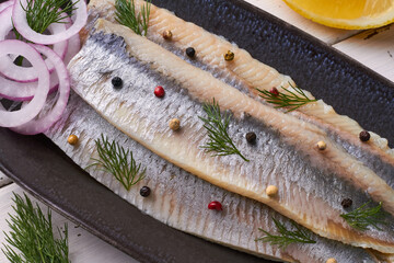 salted fillet of herring decorated with dill pepper lemon red onion