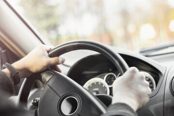 Man holding steering wheel and driving his car with highlights