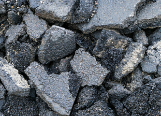Broken dark asphalt pieces close up shot, image for industrial background.