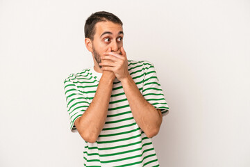 Young caucasian man isolated on white background thoughtful looking to a copy space covering mouth with hand.