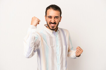 Young caucasian man isolated on white background cheering carefree and excited. Victory concept.