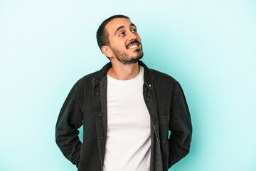 Young caucasian man isolated on blue background relaxed and happy laughing, neck stretched showing teeth.