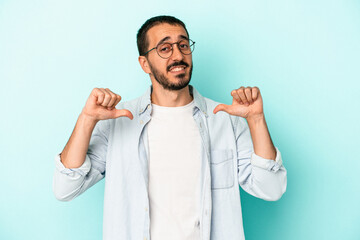 Young caucasian man isolated on blue background feels proud and self confident, example to follow.