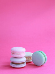 Macaron or macaroon on pink background, colorful almond cookies with different fillings