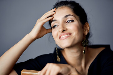 Obraz premium beautiful woman in a black dress near the chair luxury fashion dark background