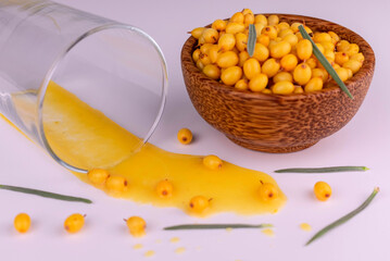 Vitamin sea buckthorn juice is poured out of a glass on a white background. Autumn vitamin product.