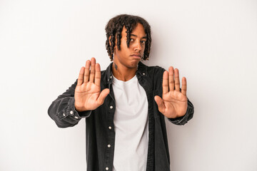 Naklejka premium Young african american man isolated on white background standing with outstretched hand showing stop sign, preventing you.