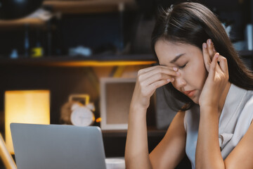 A young woman has eyestrain from using a computer for a long time.