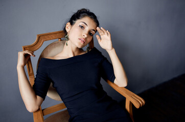 beautiful woman in a black dress near the chair luxury fashion lifestyle studio