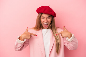 Young Russian woman isolated on pink background tired and very sleepy keeping hand on head.