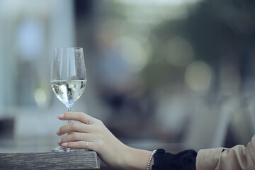 white wine glass in an outdoor cafe, spring view in a restaurant