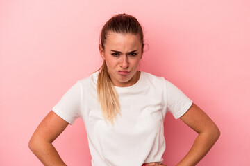 Young Russian woman isolated on pink background sad, serious face, feeling miserable and displeased.