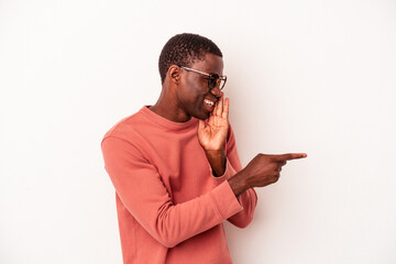 Young African American man isolated on white background saying a gossip, pointing to side reporting...