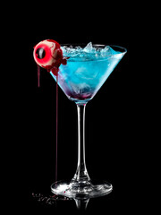Blue Halloween martini with a bloody eye on black background