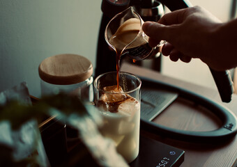 espresso shot dropping in a glass with digital coffee scale