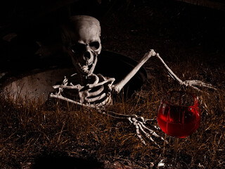 Skeleton up from a manhole and try to catch a bloody red wine glass