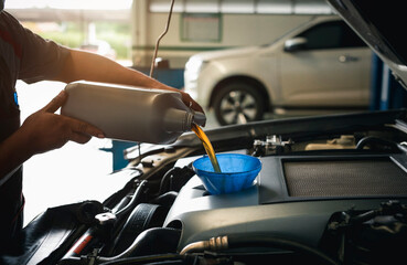 Fototapeta na wymiar Close-up of mechanic in repairing car, change the oil at service center.