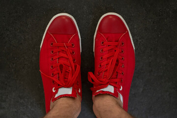 Red mens sneakers top view. Fashionable mens shoes of bright red color on grey background.