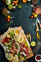 Antipasto. Italian food. Prosciutto, capers, salami, parmesan, honey on a wooden board. Top view. Rustic style.