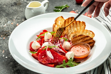 Salad with fresh tomato mozzarella, onion and olive oil. Traditional Uzbek cuisine