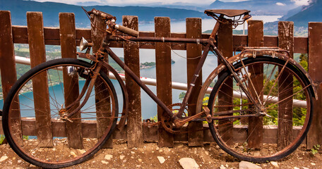 old bicycle in front of a fence