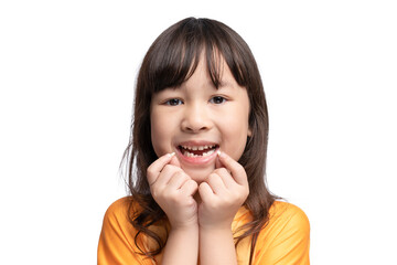 Cute Asian girl smiles showing her missing teeth in her mouth and holding her loose teeth. Tooth...