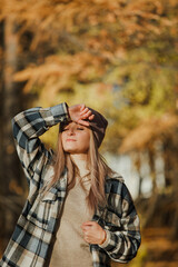 a blonde girl in a plaid shirt in the autumn forest