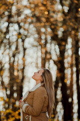 
a blonde adult girl walks in the autumn forest. a walk in the fresh air alone