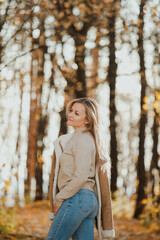 
a blonde adult girl walks in the autumn forest. a walk in the fresh air alone